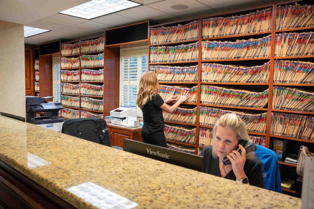 Careers at Beall Dental Center - team members working on patient files and answering the phone.